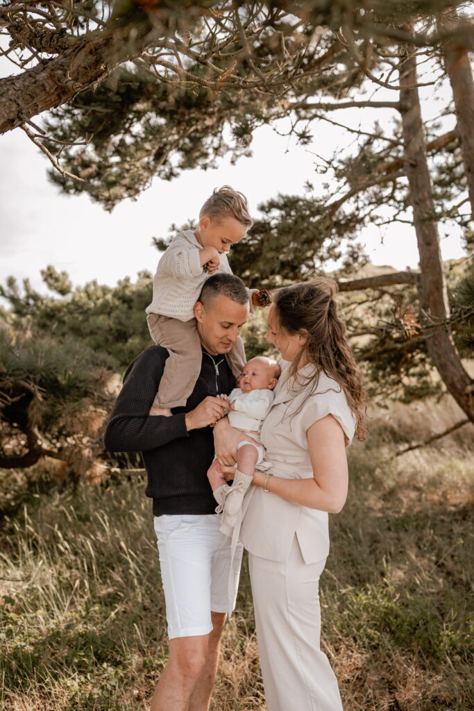 Een gezin van 4 met baby in de duinen tijdens een ongedwongen fotoshoot.